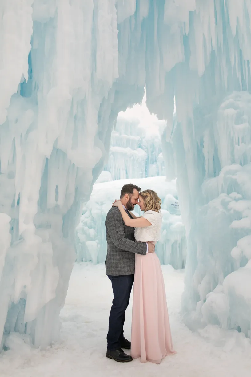 Couple embracing inside an ice castle archway