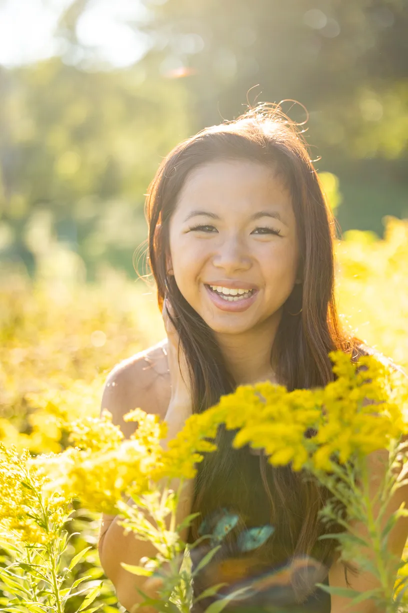 Senior portrait of a smiling teen holding goldenrod
