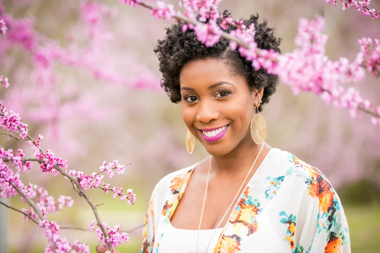 Woman smiling among pink redbud blossoms