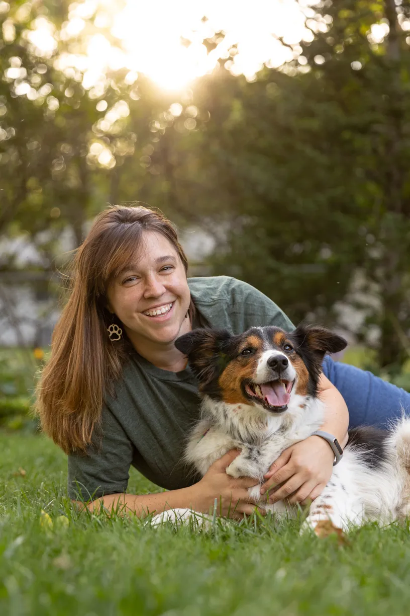 Kelly lying in the grass with one of her dogs