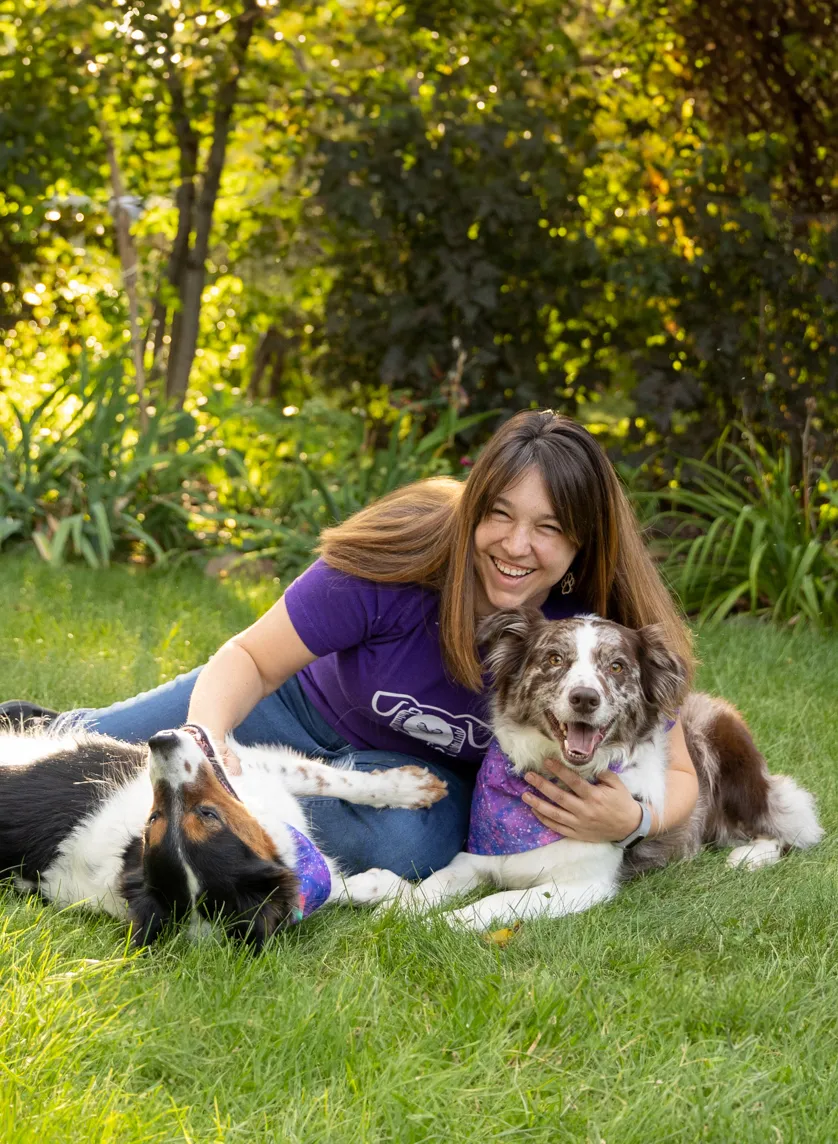 Kelly lying in the grass with her dogs